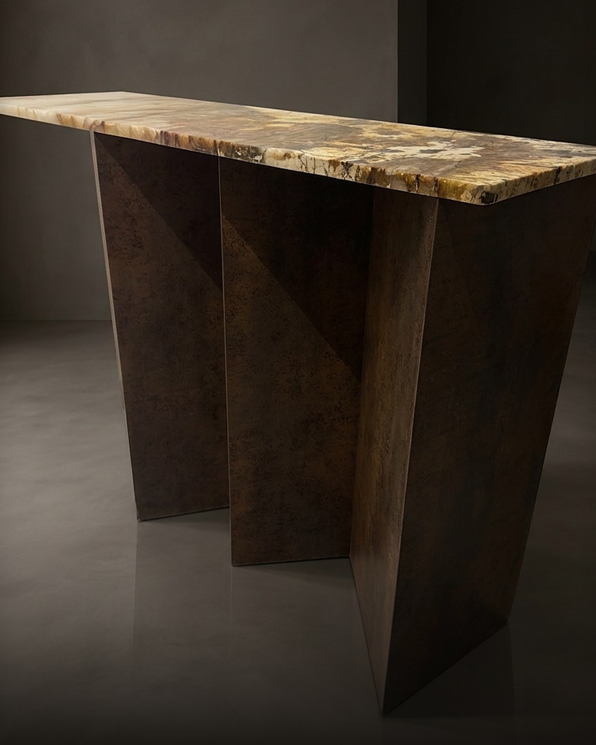 The Folded Console — a one-of-one Corten Iron Neolith console with a Patagonia quartzite top, in a dark gallery