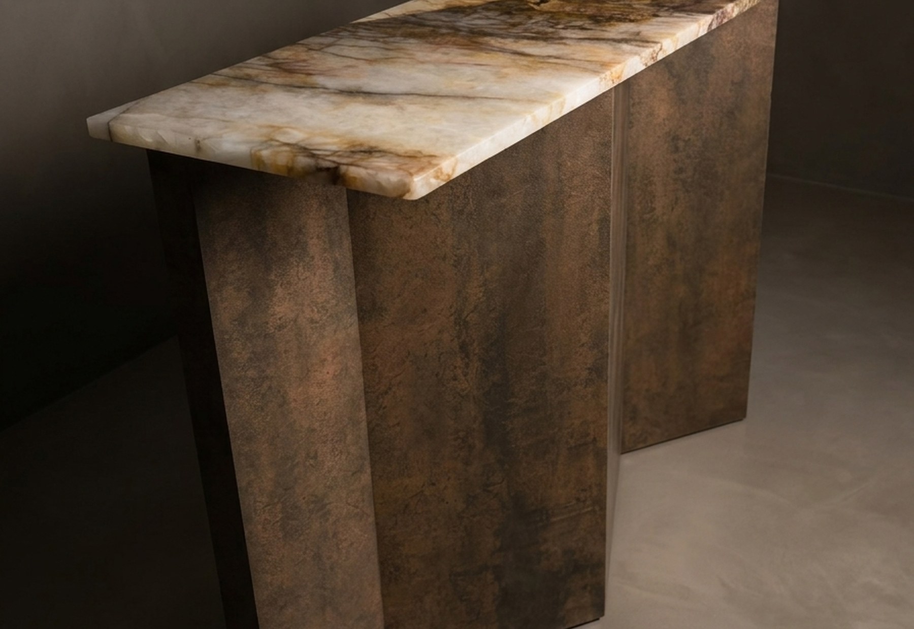 The Folded Console, front three-quarter view — the folded bronze base carrying its quartzite slab
