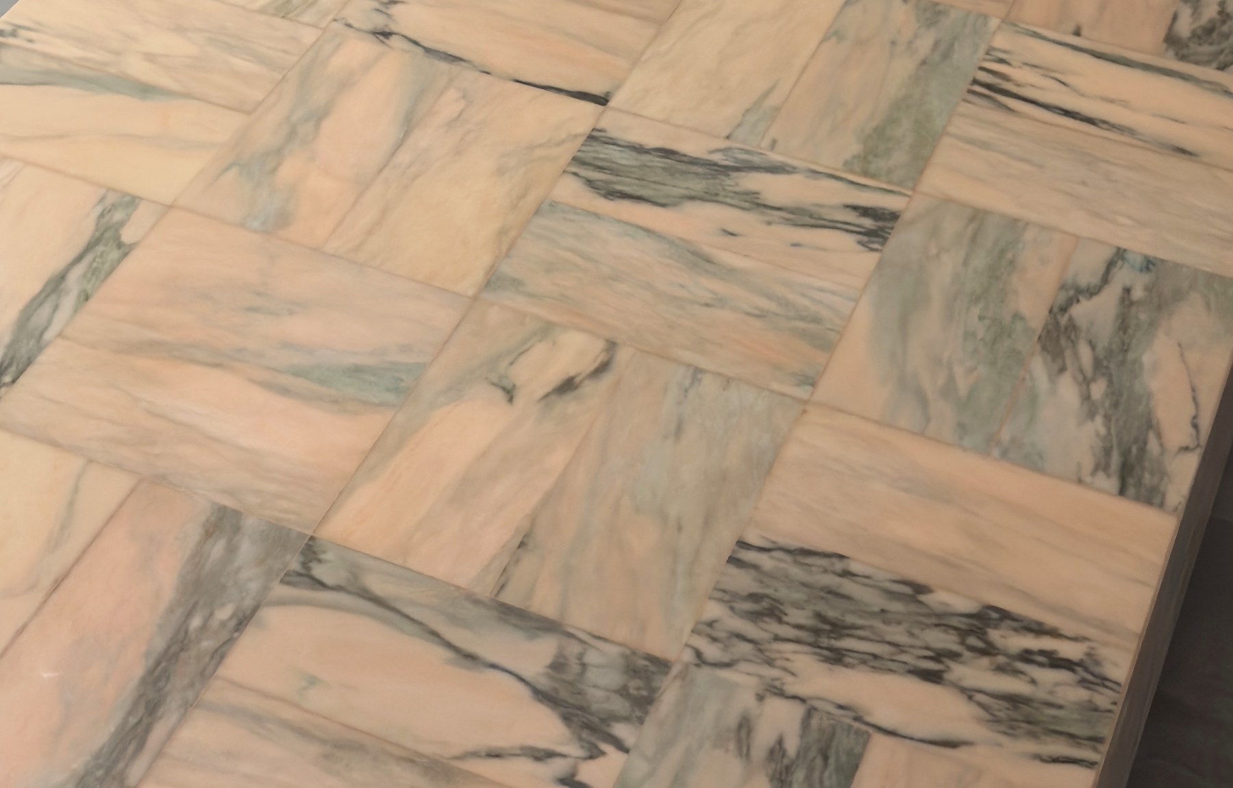 Rosa Portogallo at close range — blush pink stone with grey-green veining, the rectangles woven a quarter-turn against each other
